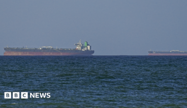 A generic image of vessels in the Strait of Hormuz. Two cargo ships upon the horizon, water in the foreground.