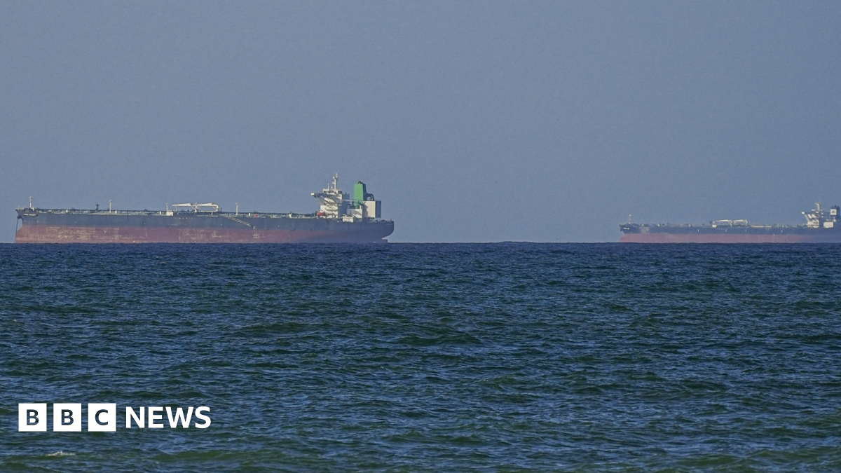A generic image of vessels in the Strait of Hormuz. Two cargo ships upon the horizon, water in the foreground.