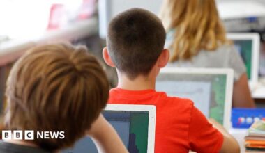 Close up image of students using laptops in a classroom.