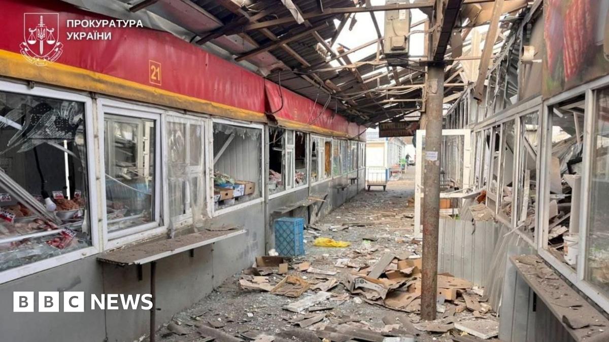 Photo provided by the Ukrainian prosecutor's office showing badly damaged indoor market area - a corridor with kiosks on either side with broken windows, and metal and glass strewn across the floor.