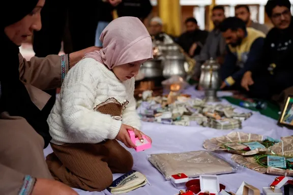 A Kashmiri Muslim girl donates a gold ring at an Imambara fund collection centre in Budgam