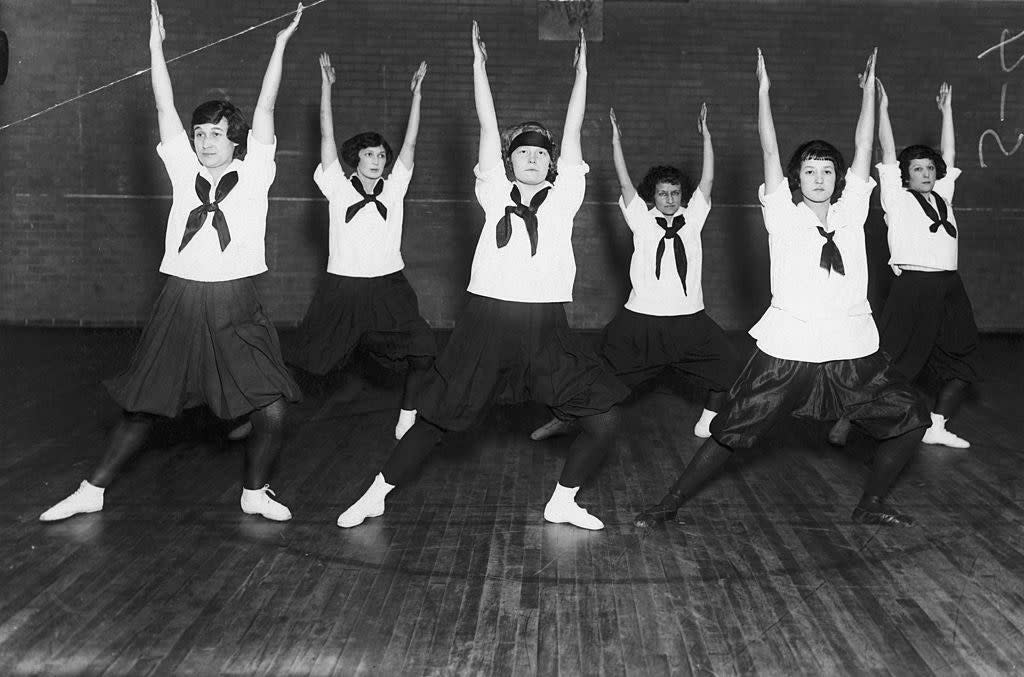 Gymnasts reach their hands to the sky doing a basic move