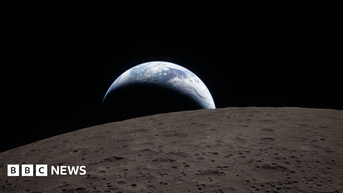 Image of Earthrise poking out over the surface of the moon