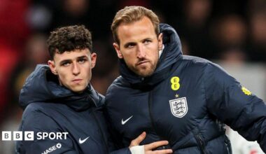 Phil Foden and Harry Kane in England blue coats after the defeat by Japan, with both players stern-faced