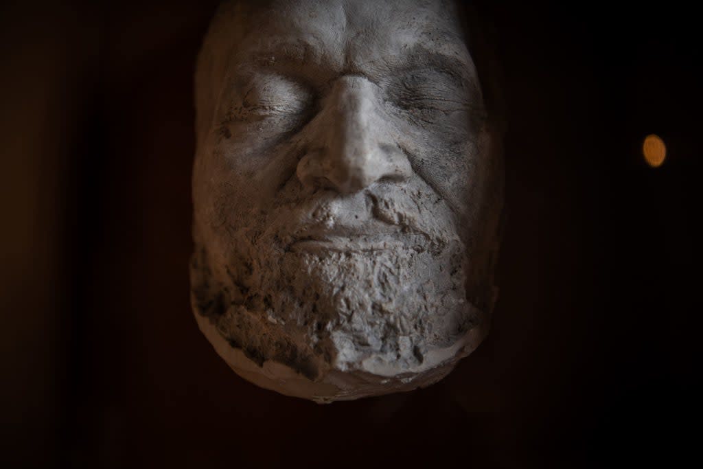 A detailed sculpture of an elderly man's face with closed eyes, focusing on natural expressions and textures