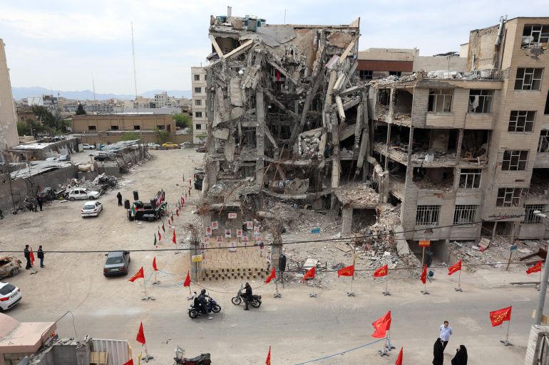 epa12886919 People gather and view photographs of people killed in a US-Israeli airstrike on a residential building, displayed in front of the same building that was hit in Tehran, Iran, 13 April 2026. Iran and the US have failed to reach an agreement after peace talks held in Islamabad on 11 April. EPA/ABEDIN TAHERKENAREH