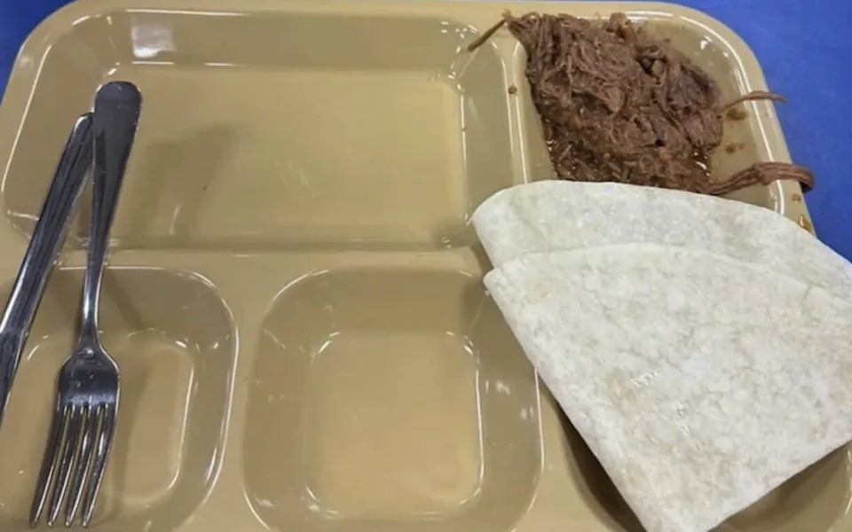 Two tortillas and some meat on a food tray served on USS Tripoli