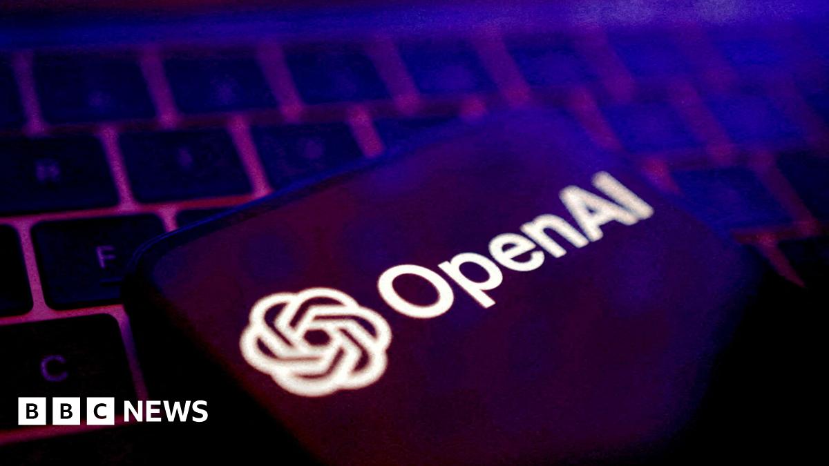 OpenAI logo displayed on a smartphone on top of a laptop keyboard.