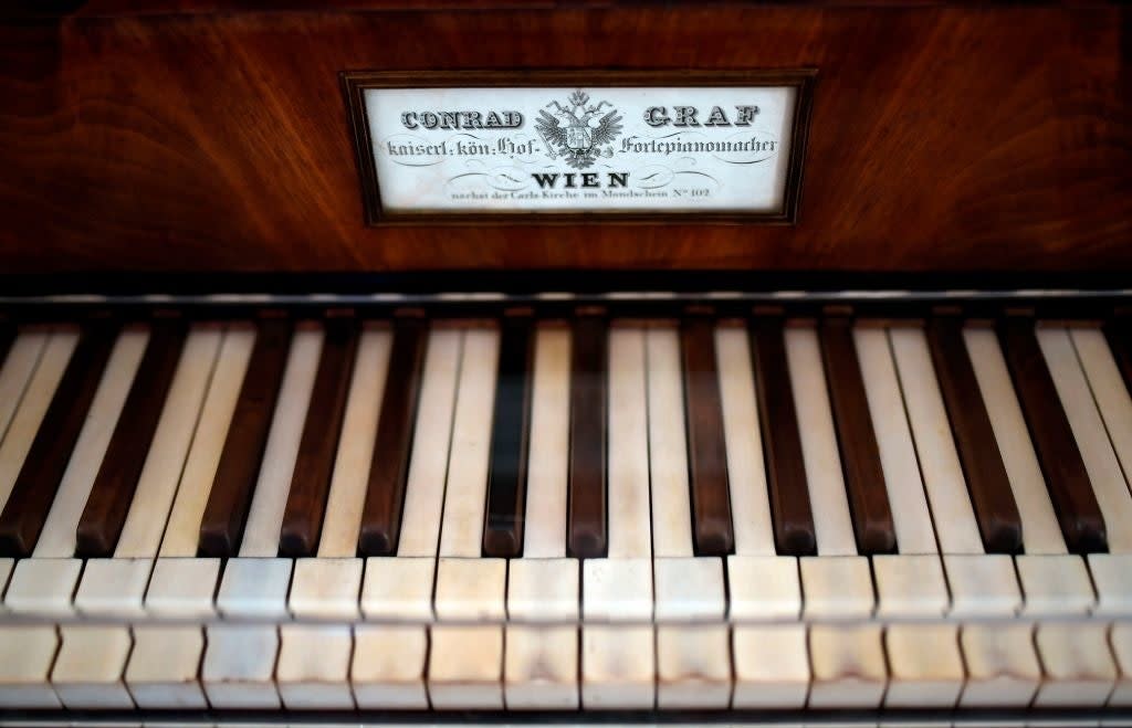 Close-up of a vintage piano keyboard with a label above the keys, reading "Conrad Graf, Wien."