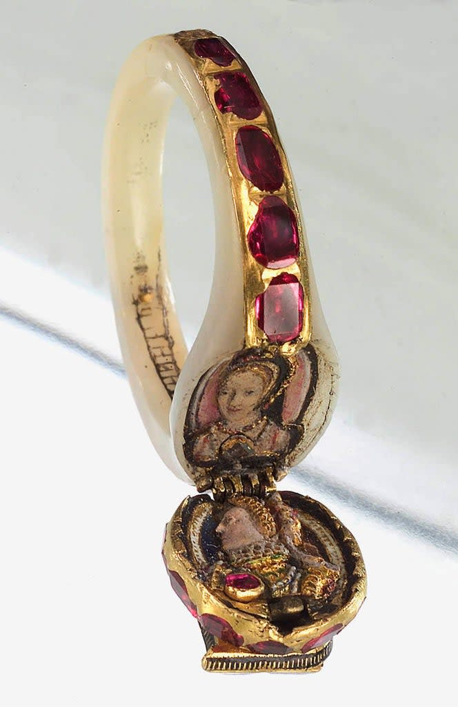Ornate gold and ruby enamel ring with a hidden hinged locket displaying detailed miniature portraits