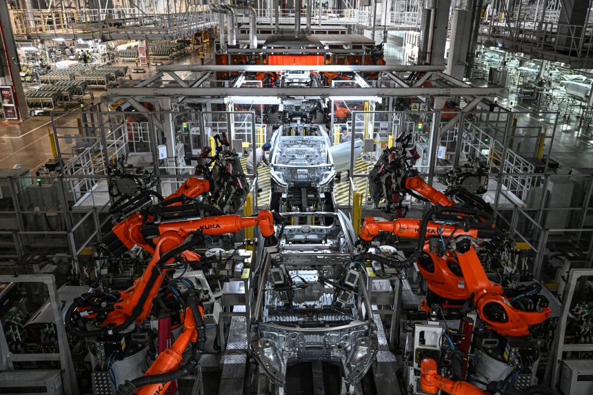 Employees and robots work on an electric vehicle production line at a factory of Chinese automaker NIO in Hefei, in eastern China's Anhui province last year.