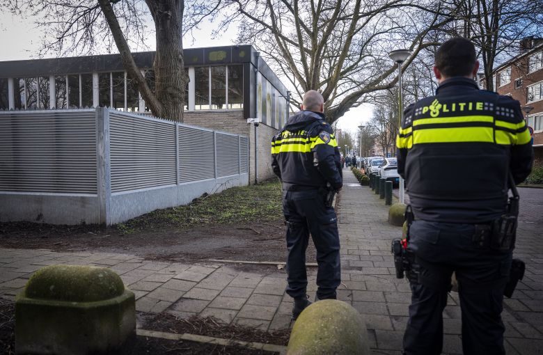 Dutch police officers stand guard near a Jewish school in Amsterdam on March 16, 2026, following its reopening after an overnight explosion against an exterior wall.