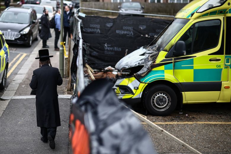 A man walks past the scene of the attack in London's Golders Green neighborhood, after volunteer ambulances run by a Jewish organization were set on fire on March 23.