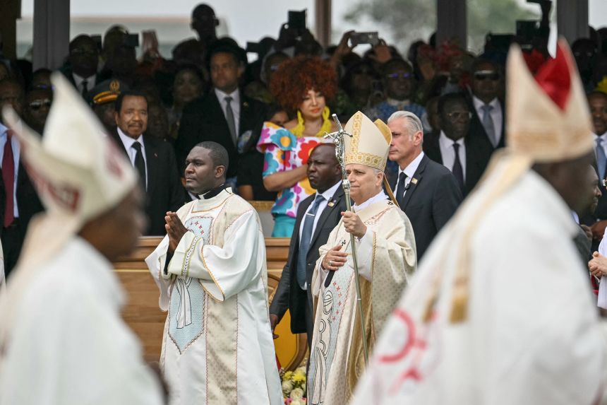 Cameroon's President Paul Biya and Cameroon's First Lady Chantal Biya watches as Pope Leo XIV (C) arrives to lead the Holy Mass at the Yaounde Ville Airport in Yaounde on April 18, 2026.
