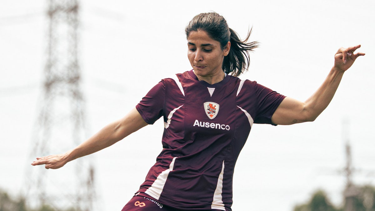 Iranian soccer player Atefeh Ramezanisadeh kicking a ball at a training session