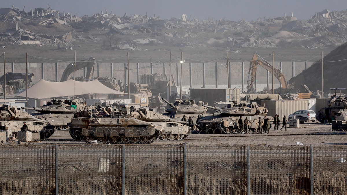 Israel Defense Forces personnel standing near military vehicles along Gaza border