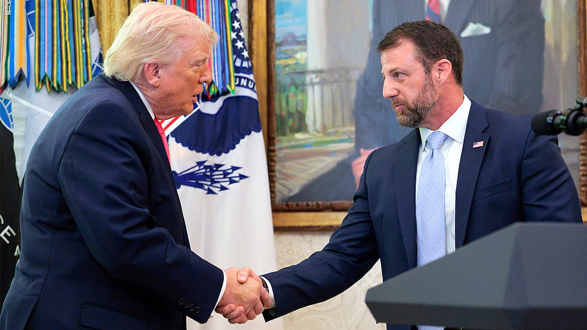 President Donald Trump shaking hands with DHS Secretary Markwayne Mullin in the Oval Office