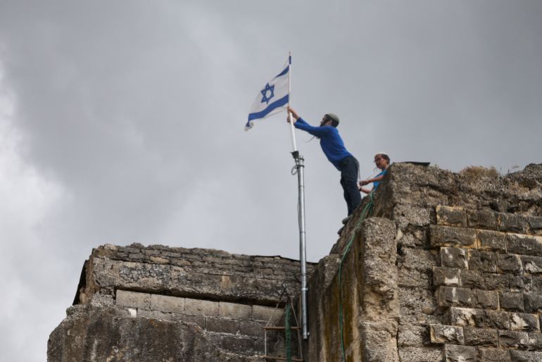 Israeli settlers place an Israeli flag atop a building, on the day of the re-establishment of the settlement of Sa-Nur, which was evacuated as part of Israel’s 2005 disengagement, in Sa-Nur in the Israeli-occupied West Bank, April 19, 2026. REUTERS/Shir Torem TPX IMAGES OF THE DAY