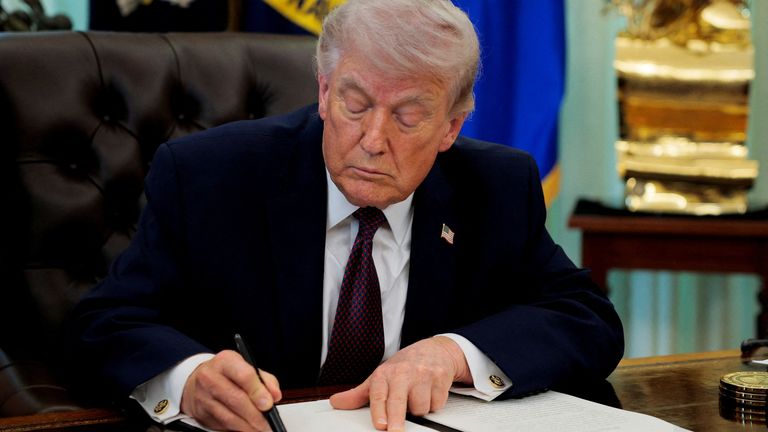 Mr Trump signing an executive order. Pic: Reuters