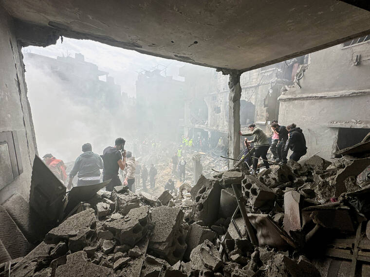 REUTERS
                                People gather today as rescuers work at the site of an Israeli strike, amid escalating hostilities between Israel and Hezbollah, as the U.S.-Israel conflict with Iran continues, in the Jnah area in Beirut, Lebanon.