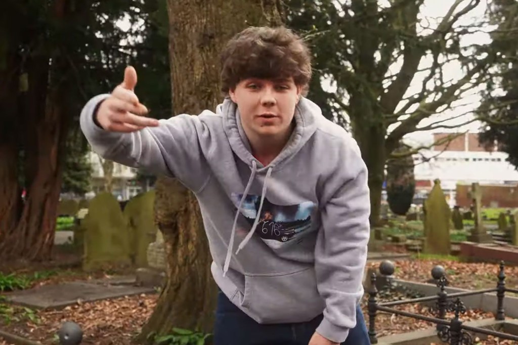 Marcus Dolman in one of his music videos, standing in a cemetery.