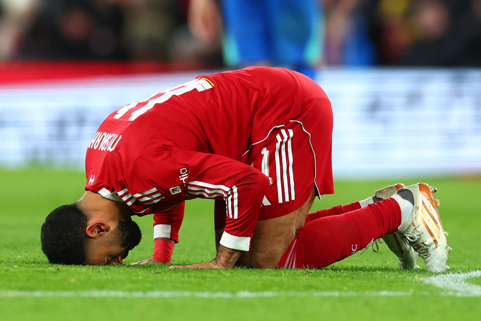A photograph of Mohamed Salah kneeling with his forehead on the turf to perform his signature sujood goal celebration, after scoring against Brighton in an FA Cup match in February 2026