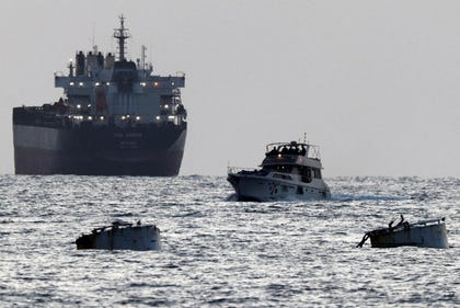 Israeli soldiers are seen on a vessel bearing symbols of the Global Sumud Flotilla, with a cargo ship behind it, as seen from Ashdod, southern Israel, Tuesday. Credit: Amir Cohen/Reuters Israeli soldiers are seen on a vessel bearing symbols of the Global Sumud Flotilla, with a cargo ship behind it, as seen from Ashdod, southern Israel, Tuesday.