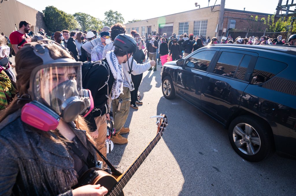 Protesters crowd around a car during a protest near the Immigration and Customs Enforcement facility at 1930 Beach St. in Broadview, Ill. on Sept. 26, 2025.