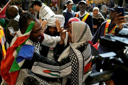 Ebrahim Peters, left, an activist embraces his family member after returning home in Johannesburg, South Africa on Saturday.