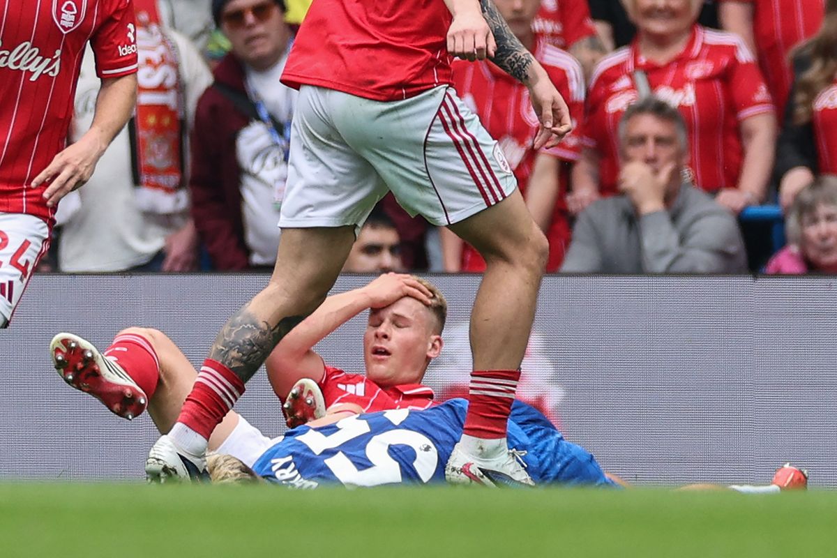 Chelsea's English striker #55 Jesse Derry (R-on ground) lies injured