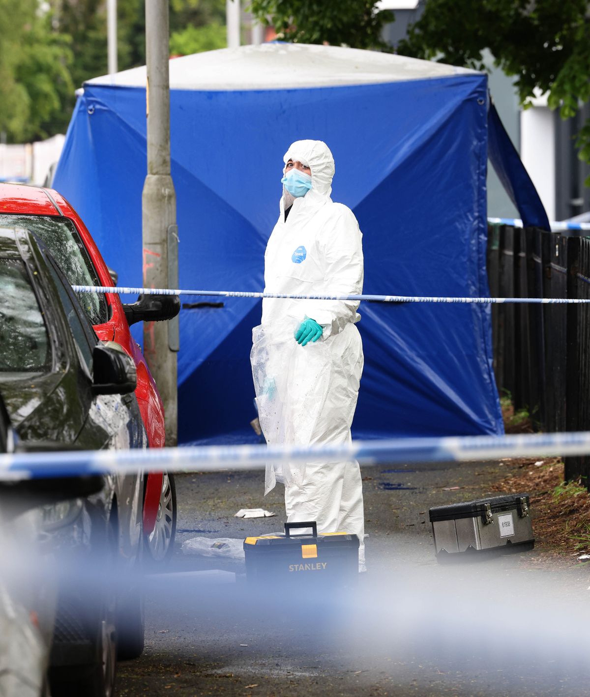 Police and forensics at the scene of a murder in Moss Side