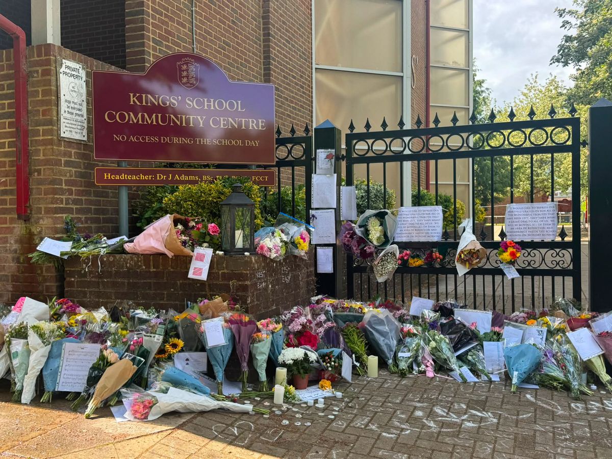 A photo of floral tributes outside the school