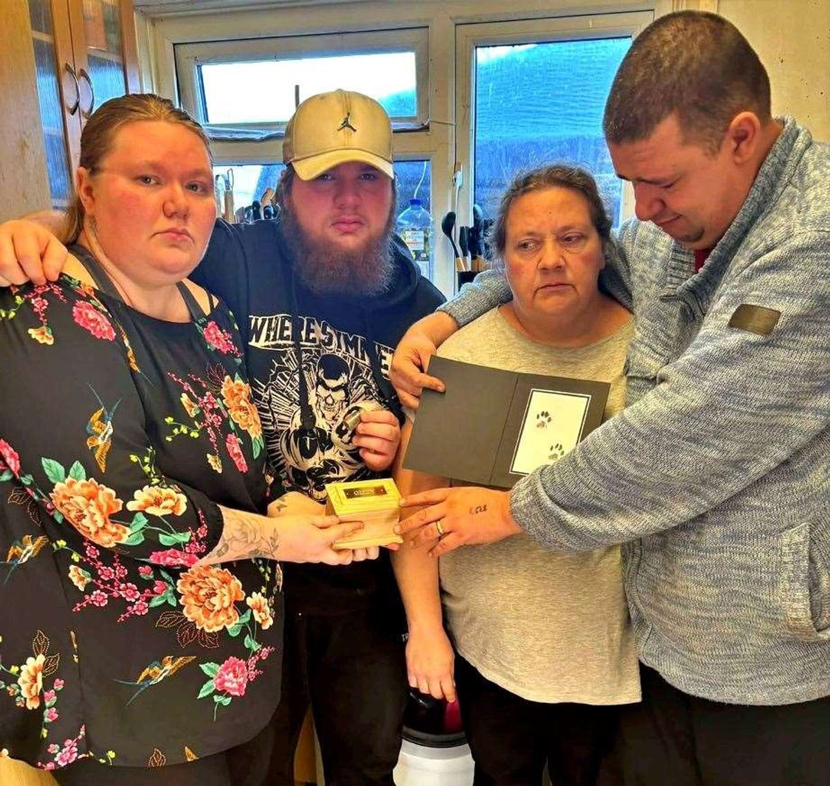 The family with Gizzy’s ashes after the 19-year-old cat was cremated