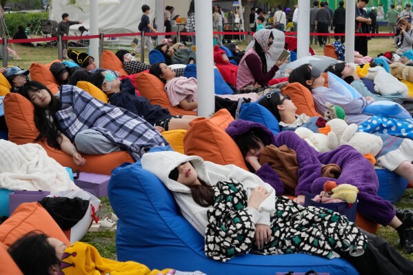 Participants take a nap during the 2026 Hangang Nap Competition at Yeouido Hangang Park in Seoul, South Korea, Saturday, May 2, 2026. (AP Photo/Ahn Young-joon)