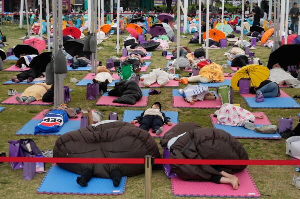 Participants take a nap during the 2026 Hangang Nap Competition at Yeouido Hangang Park in Seoul, South Korea, Saturday, May 2, 2026. (AP Photo/Ahn Young-joon)