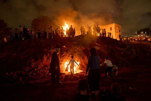 Ultra-Orthodox Jews dance around a bonfire during Lag BaOmer, a Jewish holiday traditionally marked by bonfire, music, and communal celebrations, in Bnei Brak, Israel, Monday, May 4, 2026. (AP Photo/Oded Balilty)