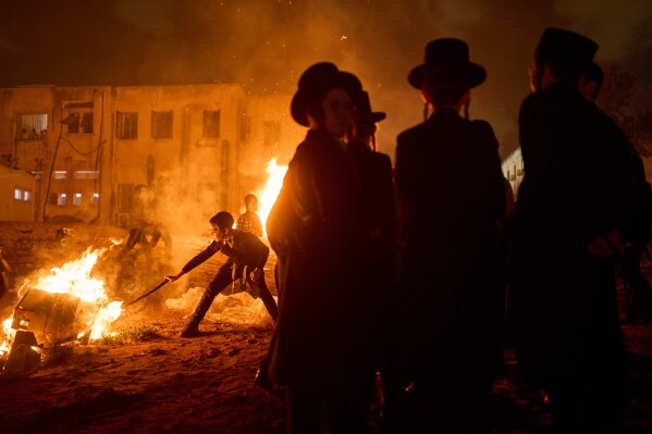 Ultra-Orthodox Jews gather around a bonfire during Lag BaOmer, a Jewish holiday traditionally marked by bonfire, music, and communal celebrations, in Bnei Brak, Israel, on Monday, May 4, 2026. (AP Photo/Oded Balilty)