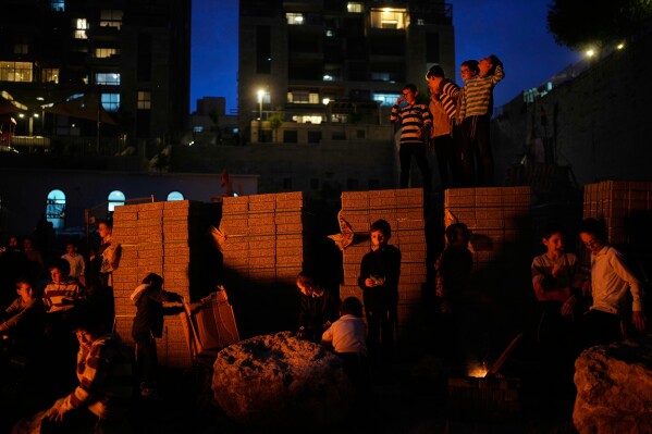 Ultra-Orthodox Jewish boys stand around a bonfire during Lag BaOmer, a holiday traditionally celebrated with bonfires, music, and gatherings, in Jerusalem, Monday, May 4, 2026. (AP Photo/Ohad Zwigenberg)