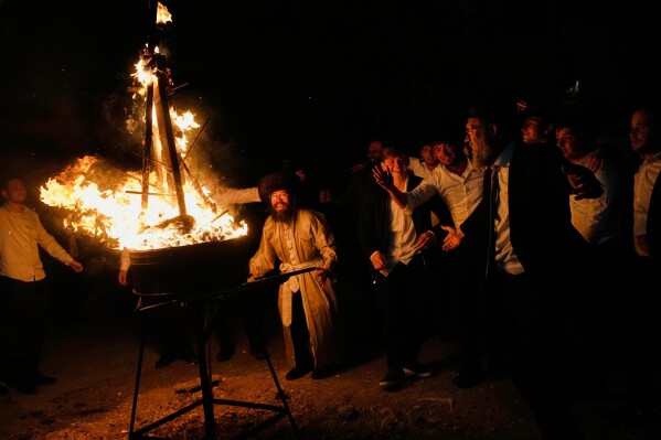 Ultra-Orthodox Jews dance around a bonfire during Lag BaOmer, a Jewish holiday traditionally celebrated with bonfires, music, and gatherings, at the Orthodox neighborhood of Mea Shearim, in Jerusalem, Monday, May 4, 2026. (AP Photo/Ohad Zwigenberg)