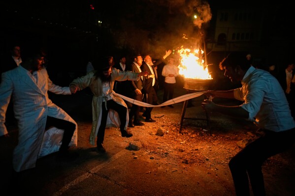 Ultra-Orthodox Jews dance around a bonfire during Lag BaOmer, a Jewish holiday traditionally celebrated with bonfires, music, and gatherings, at the Orthodox neighborhood of Mea Shearim, in Jerusalem, Monday, May 4, 2026. (AP Photo/Ohad Zwigenberg)