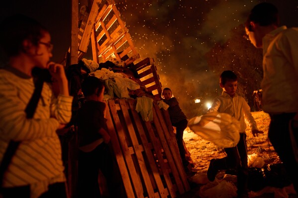 Ultra-Orthodox Jews gather around a bonfire during Lag BaOmer, a Jewish holiday traditionally marked by bonfire, music, and communal celebrations, in Bnei Brak, Israel, Monday, May 4, 2026. (AP Photo/Oded Balilty)