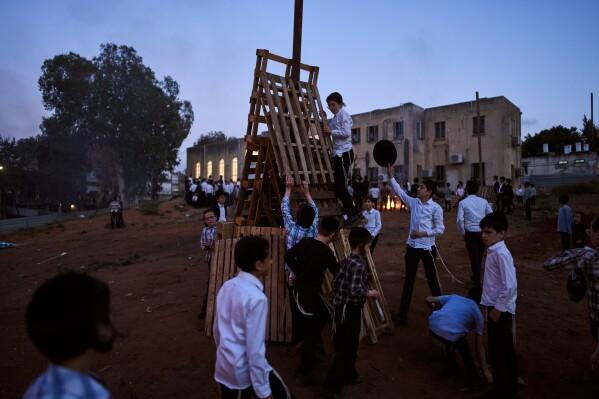 Ultra-Orthodox Jewish children build bonfires in preparation for Lag BaOmer, a Jewish holiday traditionally marked by bonfire, music, and communal celebrations, in Bnei Brak, Israel, Monday, May 4, 2026. (AP Photo/Oded Balilty)