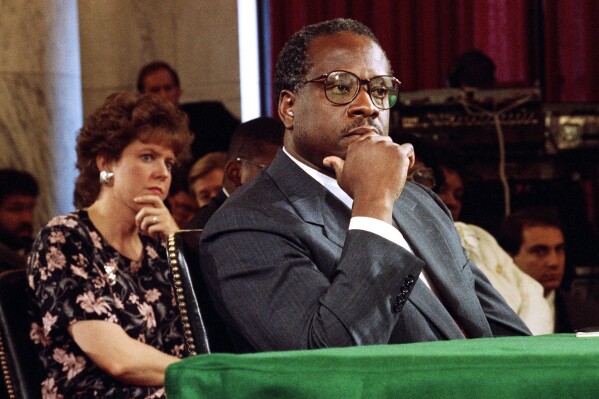Supreme Court Justice Nominee Clarence Thomas and his wife Virginia listen during his nomination hearing before the Senate Judiciary Committee on Capitol Hill in Washington, Sept. 10, 1991. (AP Photo/Doug Mills, File)