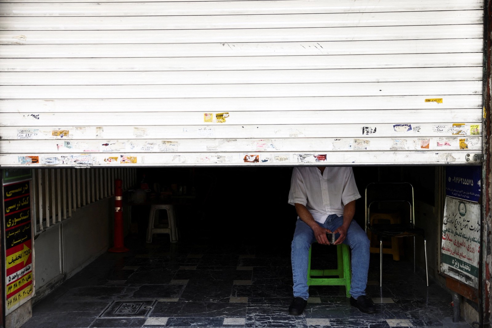 A man sit at his shop in a street, after US President Donald Trump said that he had agreed to a two-week ceasefire with Iran, in Tehran, Iran, April 8, 2026.