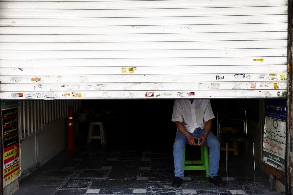 A man sit at his shop in a street, after US President Donald Trump said that he had agreed to a two-week ceasefire with Iran, in Tehran, Iran, April 8, 2026.