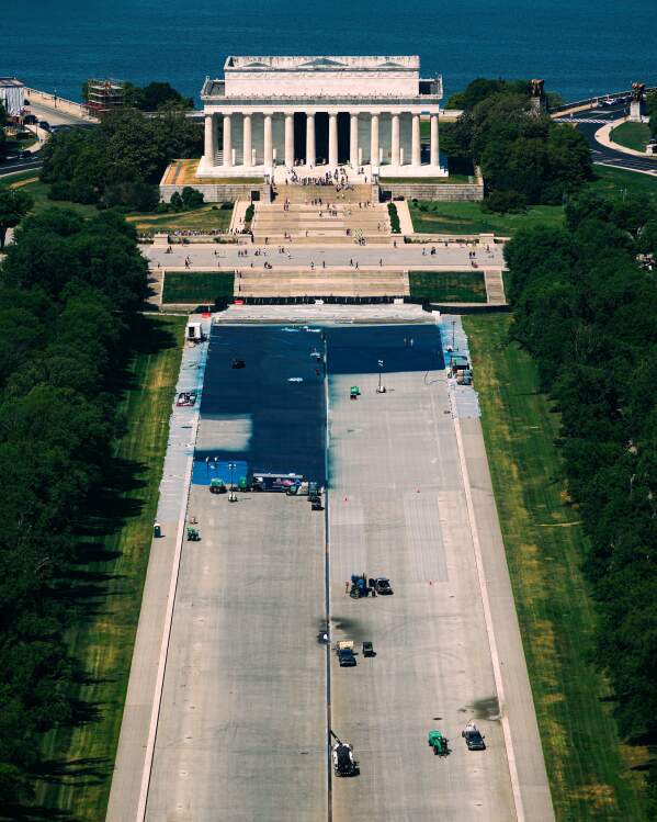Workers coat the Lincoln Memorial Reflecting Pool in a blue swimming pool surface, covering up a decades-old granite surface, ahead of America 250, Tuesday, May 5, 2026, seen from the Washington Monument in Washington. (AP Photo/Julia Demaree Nikhinson)