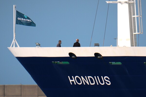 Passengers stand on the deck of the hantavirus-stricken cruise ship MV Hondius after its arrival at the port of Granadilla in Tenerife, Canary Islands, Spain, Sunday, May 10, 2026. (AP Photo/Manu Fernandez)