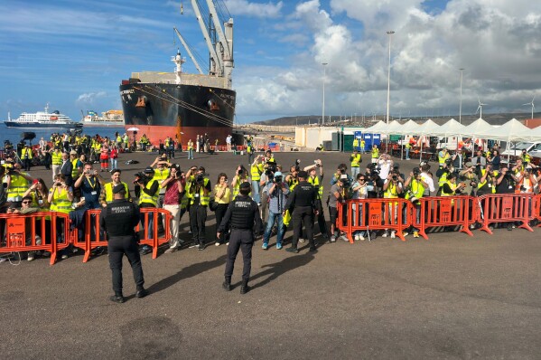 Media members work next the hantavirus-stricken cruise ship MV Hondius at the port of Granadilla in Tenerife, Canary Islands, Spain, Sunday, May 10, 2026. (AP Photo)