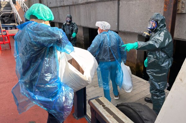 Passengers are disembarked from the hantavirus-stricken cruise ship MV Hondius at the port of Granadilla in Tenerife, Canary Islands, Spain, Sunday, May 10, 2026. (AP Photo)