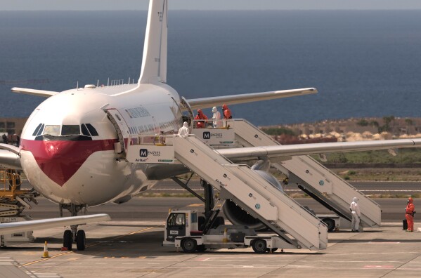 A passenger boards a Spanish government plane after disembarking from the hantavirus-stricken cruise ship MV Hondius at the airport in Tenerife, Canary Islands, Spain, Sunday, May 10, 2026. (AP Photo/Arturo Rodriguez)
